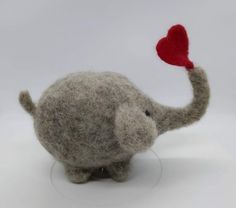 an elephant holding a red heart in its trunk