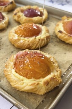 baked pastry items being drizzled with syrup