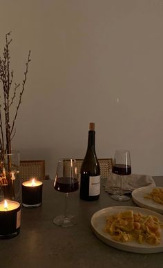 the table is set with wine, food and candles