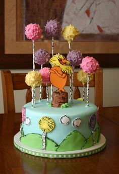 a cake with frosting and flowers on it sitting on top of a wooden table