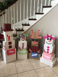 cardboard boxes are stacked up on the floor in front of a staircase decorated for christmas