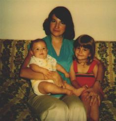 a woman and two children sitting on a couch