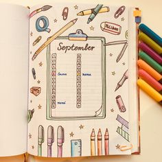 an open notebook with colored pencils on it