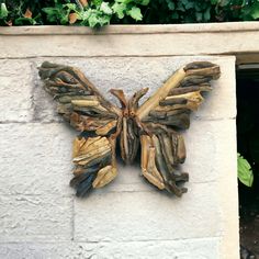 a butterfly made out of drift wood on a wall