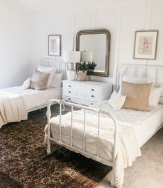 a bedroom with two beds and a rug on the floor