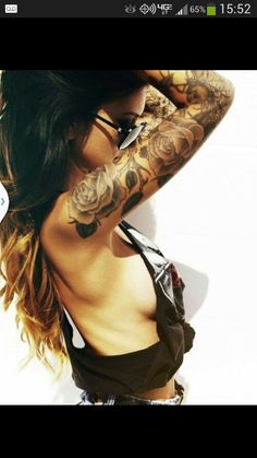 a woman with tattoos on her arm and chest