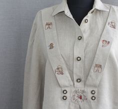 Vintage embroidered linen trachten shirt  Beige embroidered trachten linen blouse with long sleeves. Decorated with machine embroidery on the clasp. Used condition but no stains or holes. The label says size 42, which is XL. compare our measurements with yours. Dimensions: shoulder 5.5". Armpit to armpit: 22 inch Length: 27.5 inches Sleeve length: 23 inches Go to Oktoberfest or have a Tyrolean party with your friends in this dress! Enjoy! Embroidered Fitted Linen Tops, Fitted Embroidered Linen Tops, Embroidered Linen Button-up Top, Linen Button-up Top With Embroidery, Linen Embroidered Button-up Top, Fitted Linen Blouse With Floral Embroidery, Women Cottagecore, Dirndl Blouse, Embroidered Linen