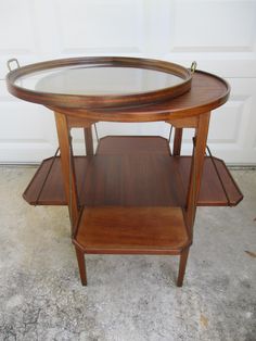 a wooden table with two glass shelves on each side and a door in the background