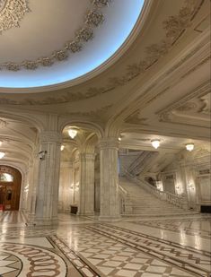 the inside of a building with marble floors and walls, chandeliers and stairs