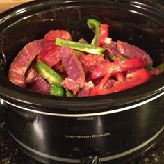 a slow cooker filled with meat and vegetables