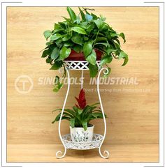 a potted plant sitting on top of a white stand next to a wooden wall