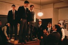 men in suits and ties standing on top of a podium with other people around them