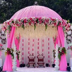 an outdoor wedding setup with pink drapes and flowers