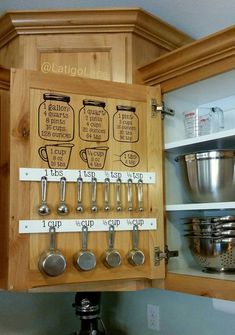 a kitchen cabinet with measuring spoons and measuring cups on the bottom, labeled in black