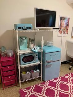 an old fashioned refrigerator and microwave in a room with pink rugs on the floor