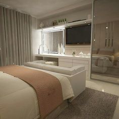 a bedroom with a bed, dresser and tv in it's corner area next to a sliding glass door