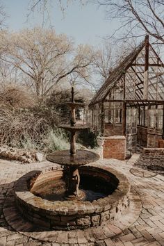 a water fountain in the middle of a brick patio