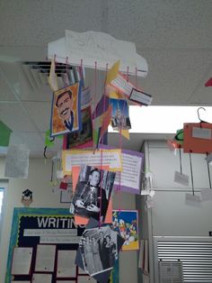 an office cubicle with posters and pictures hanging from the ceiling