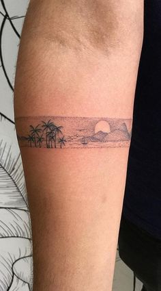 a man's arm with a small palm tree tattoo on it