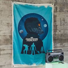 there is a poster on the wall next to an old boombox and radio set