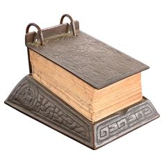 an old book is sitting on top of a metal stand