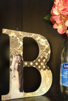 the letter b is next to a vase with flowers on it and a bottle of water