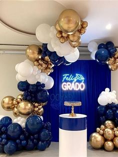 balloons and streamers are on display in front of a blue backdrop with gold accents