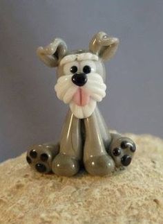 a small dog figurine sitting on top of a rock