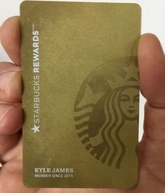 a person holding up a starbucks card in their hand