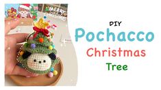 a hand holding a small crocheted christmas tree ornament