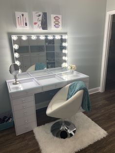 a white chair sitting in front of a desk with a mirror on top of it