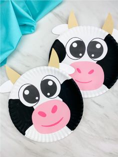 two paper plates with cows painted on them