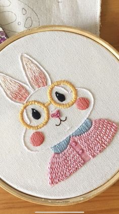 a close up of a embroidery on a piece of cloth with an animal wearing glasses