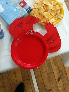 a table topped with red plates and bowls filled with food covered in googly eyes