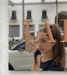 a woman taking a selfie in front of a building with the letter i on it