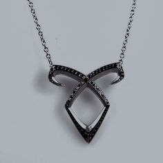 a black and white diamond necklace on a chain with an arrow shaped pendant hanging from it