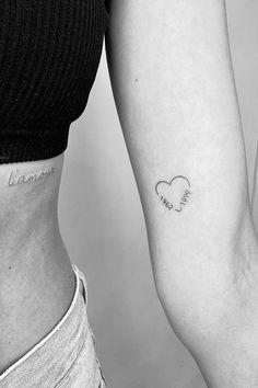 two people with tattoos on their arms and one has a small heart in the middle