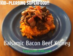 a blue plate topped with food on top of a wooden table next to a sign that says, kid - pleasing superfood balsamic bacon beef kidney