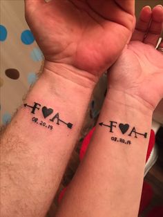 two people with matching tattoos on their arms, one has a heart and the other has an arrow