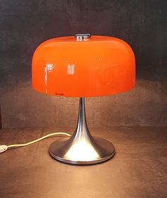 an orange lamp sitting on top of a table