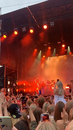 a group of people standing on top of a stage with their hands in the air