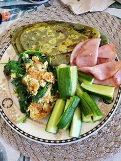 a plate with meat, vegetables and other food items on it sitting on a table