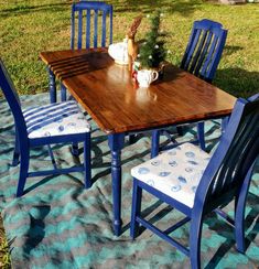 a wooden table with blue chairs on a blanket