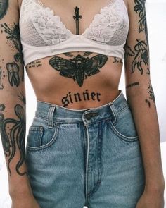 a woman with tattoos on her stomach and chest is standing in front of a white background