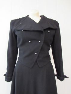 "Vintage 1940s women's suit, jacket and skirt. Made of black rayon/wool. Double breasted military or riding style. Has chrome ball buttons, short cropped, full skirt and pointed turned up cuffs with functional button. Quality construction. No label. Size small. Actual measurements of the jacket: Bust: 34\" waist: 28\" Shoulder seam to shoulder seam: 15.5\" Shoulder seam to cuff: 21.5\" Overall length: 21\" Skirt: waist: 23\" hips: 44\" length: 30\" In excellent condition." Formal Fitted Blazer With Epaulettes, Fitted Blazer With Epaulettes For Workwear, Fitted Uniform-style Blazer With Buttons, Fitted Uniform Blazer With Buttons, Fitted Uniform Style Blazer With Buttons, Fitted Double-breasted Uniform Blazer, 1940s Suit, Chrome Ball, 1940s Woman