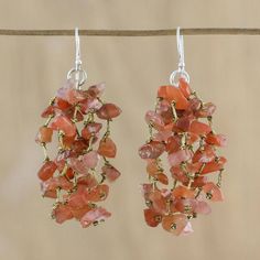 The red-orange hues of natural rain fall from the ears in this pair of waterfall earrings from Thailand. Designed by Sasina each earring features carnelian stones strung on silk threads. The earrings hang on hooks of sterling silver. Natural Rain, Waterfall Earrings, Pearl Chandelier Earrings, Pearl Cluster Earrings, Pearl Chandelier, Carnelian Stone, Pearl Cluster, Cluster Earrings, Women Artisans