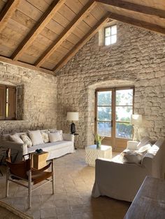 a living room filled with furniture and stone walls