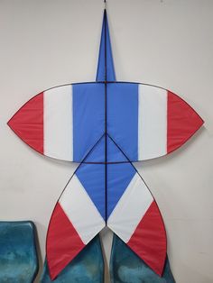 a red, white and blue kite hanging on the wall