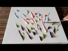 someone is cutting up some colored pencils on a white board with green and blue tips