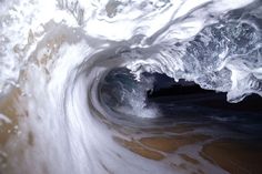 the inside of a large wave in the ocean with water splashing on it's sides